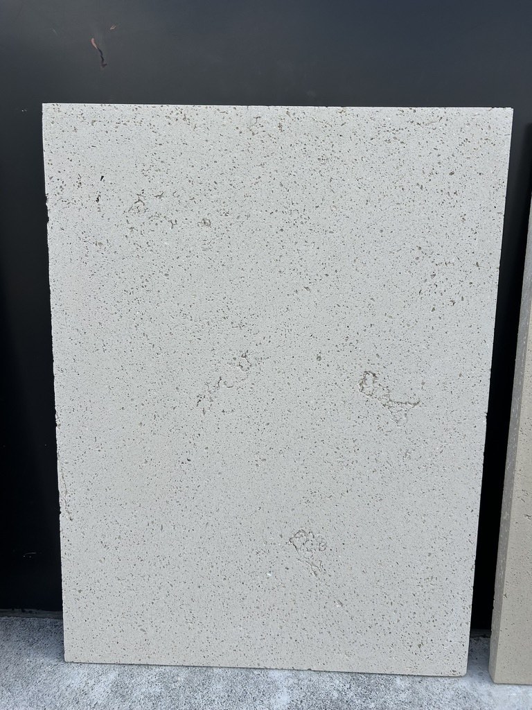 A rectangular concrete finish sample photographed against a dark background
